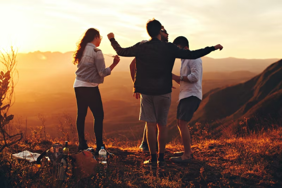 four youth on a mountain top dancing